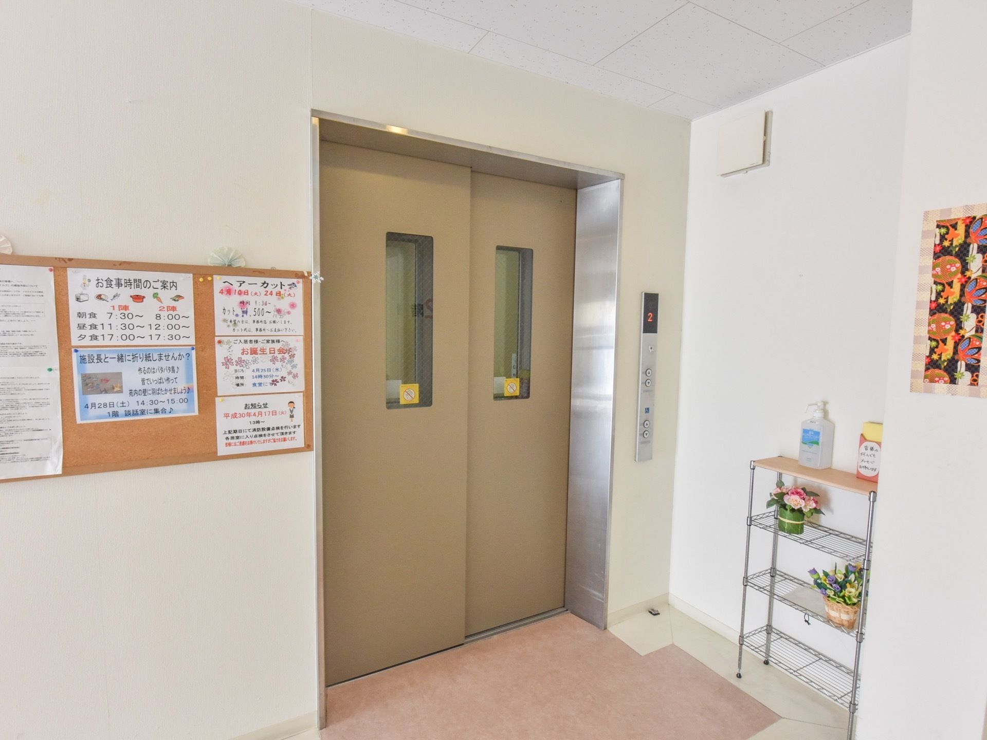 ３階の施設の中にエレベーターが完備されている。横の掲示板に案内が貼り出されている。手のアルコール除菌が置いてある。