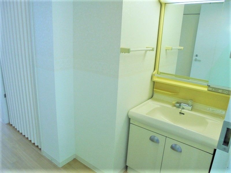 施設内の居室に用意されている洗面台の様子。鏡と物入がついている一般的な洗面台
