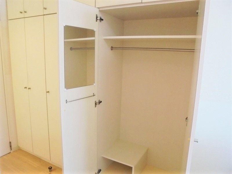 洋服をかけられるクローゼットと物入がそろった施設内居室の収納設備