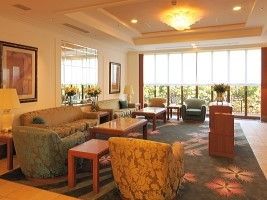 ホテルのラウンジのように広い場所。やわらかい照明とソファ、いすなどがある