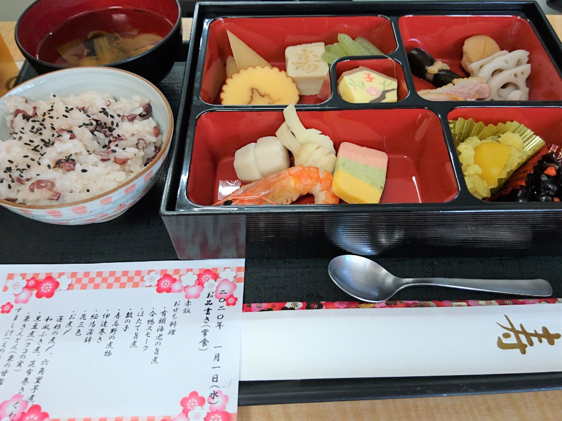 伊達巻や栗きんとんなどのおせち料理を重箱に盛り付け、お赤飯と汁物を加えた元日の食事