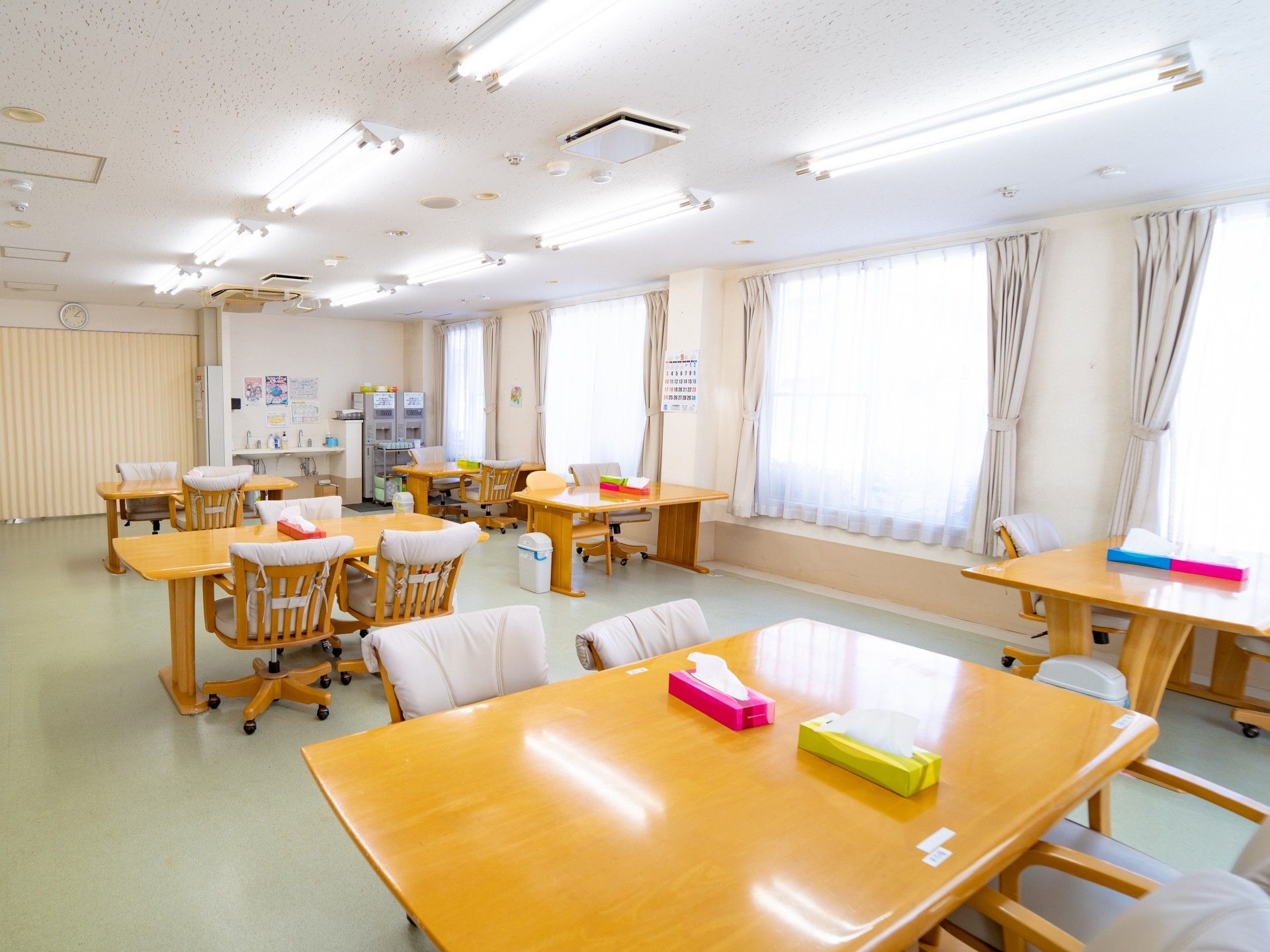 多くのテーブルと椅子がある共有スペース