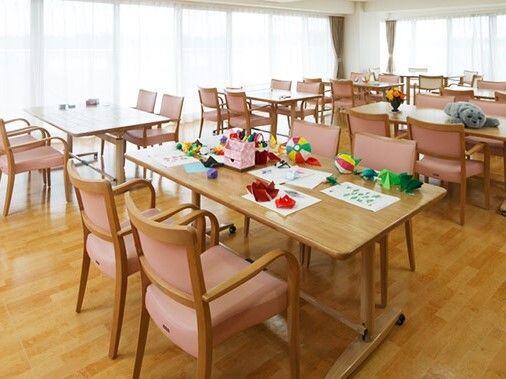 ピンクの椅子がセットされたダイニングテーブルが並ぶ食堂には、大きな窓もあり明るい雰囲気。