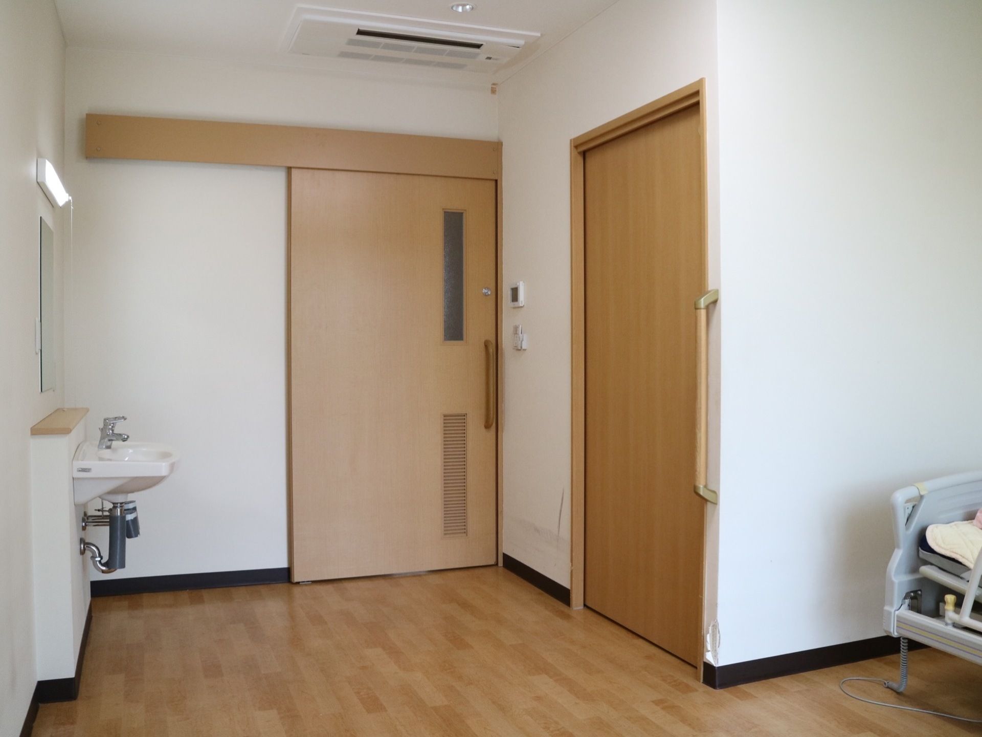 居室内にはトイレと洗面台といった水廻りの設備が整えられている。安全のため、各所に手すりが設置されている。