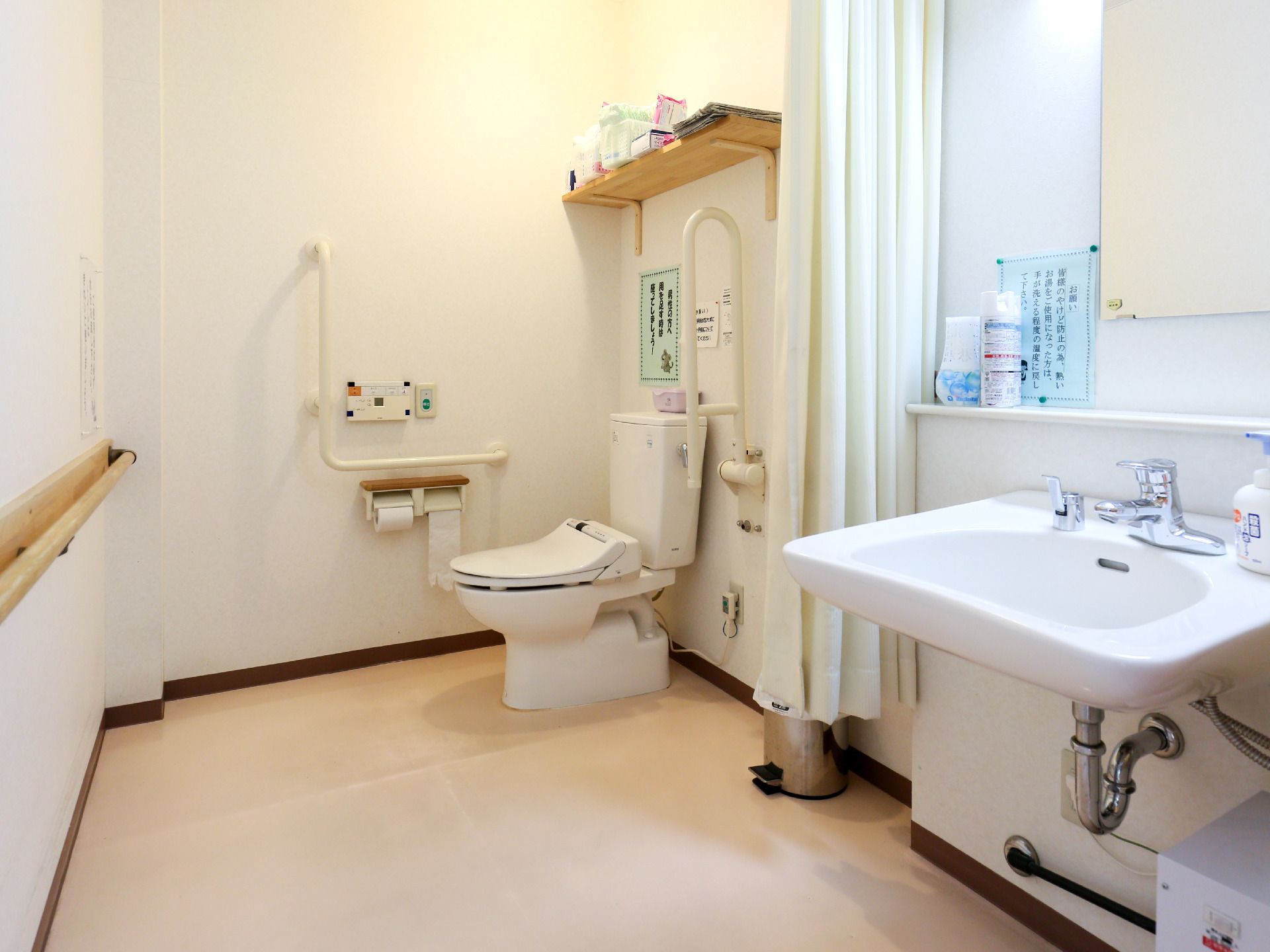 便座横にスペースを設け、両側に手すりを設置したトイレ個室