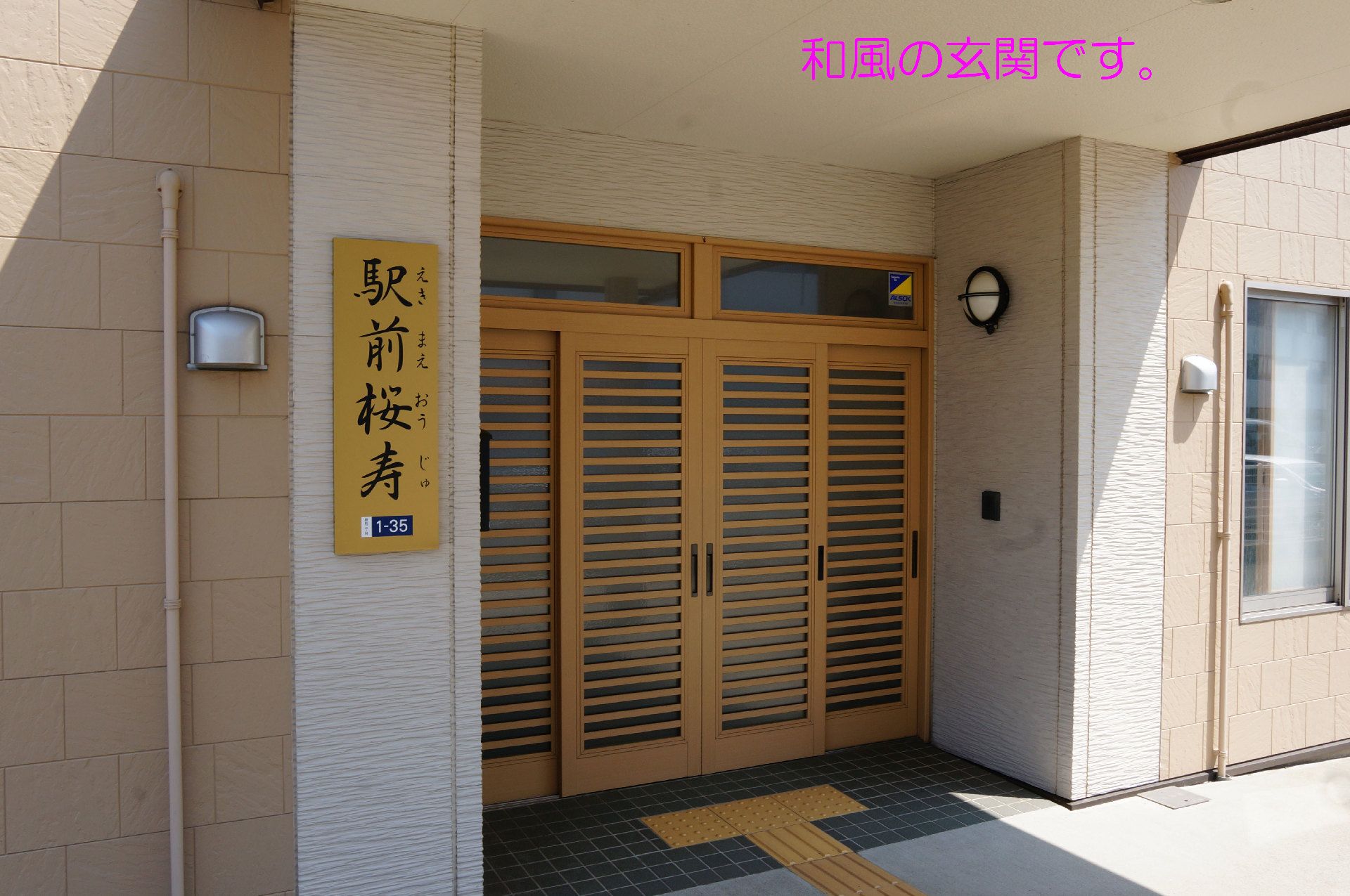 エントランス部分をアップにした写真。日本家屋風の引き戸の玄関が写っている