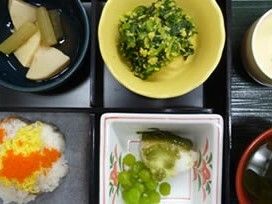 花形のちらし寿司やタケノコと拭きの煮物、豆が添えられた魚など、６つに分けられた弁当箱風の器に盛られている。