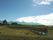 稲刈りの後田んぼで稲が干されている風景。空は青く、周辺には自然が豊富にある。