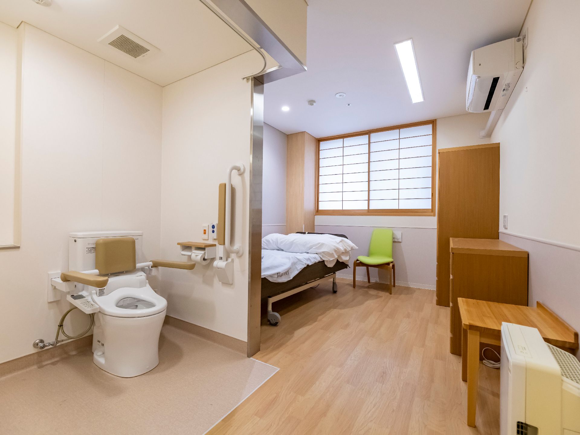 トイレとベッドが配置された白い壁の部屋