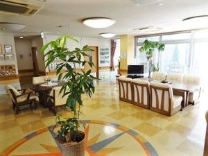 広々としたエントランスには複数の応接セットが置かれ、写真や観葉植物が飾られている。