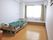 居室には大きな窓があり、カーテンが取り付けられている。部屋にはエアコンや介護用ベッドが設置されている。