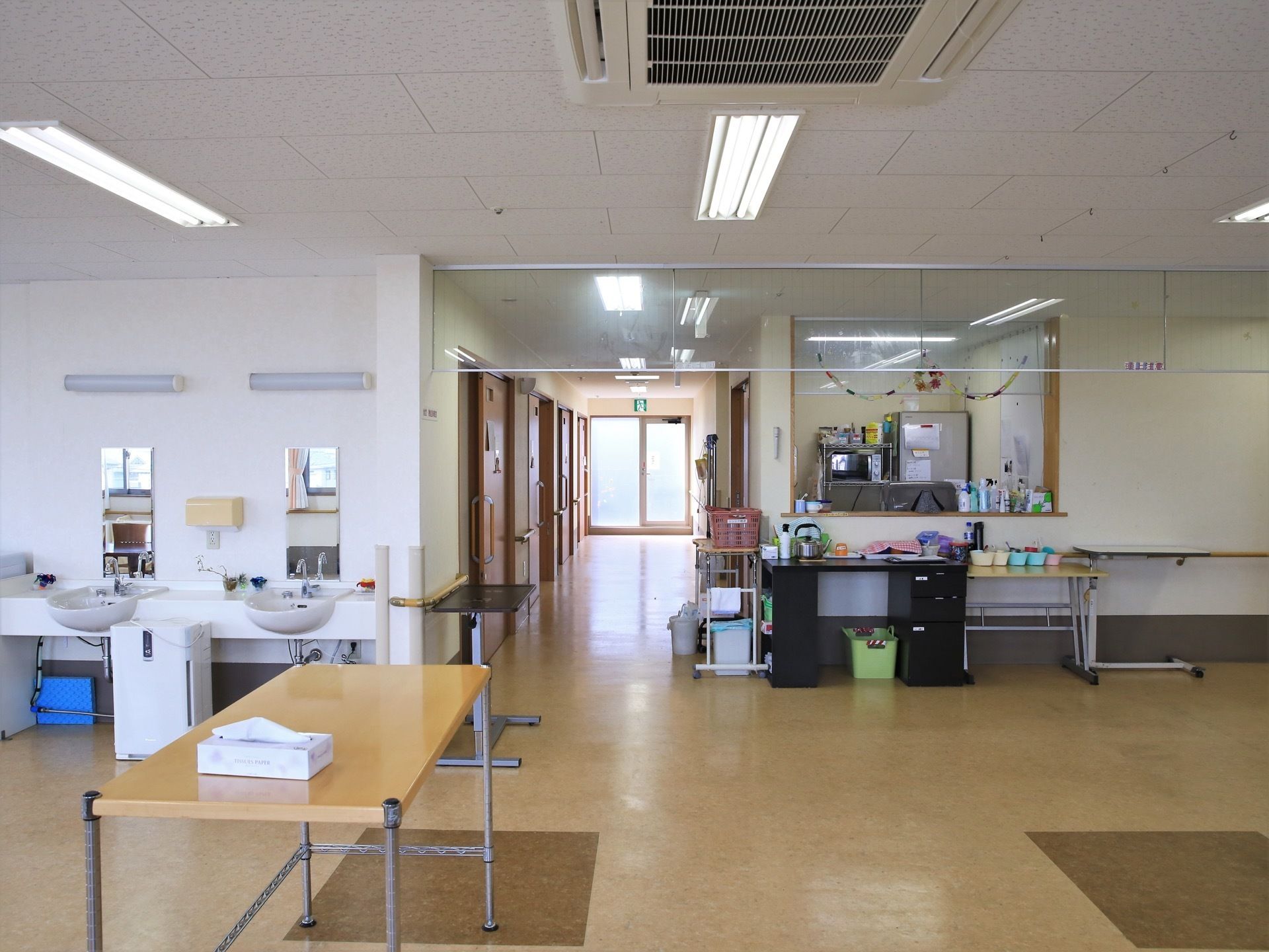 中央に通路があり、天井には埋め込み式のエアコンが設置されている。また、壁際には洗面台が２台並んであり、前面に縦長の鏡が取り付けられている。