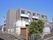 日差しを遮るような高い建物などが周囲にない敷地に建つ３階建ての施設である。敷地境界にはフェンスが立てられている。