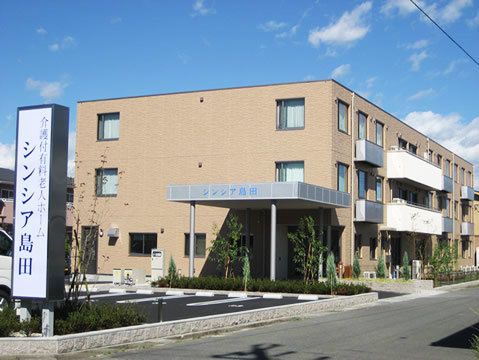 やわらかい色合いの鉄骨造の建物の様子。マンション風の建物の外観