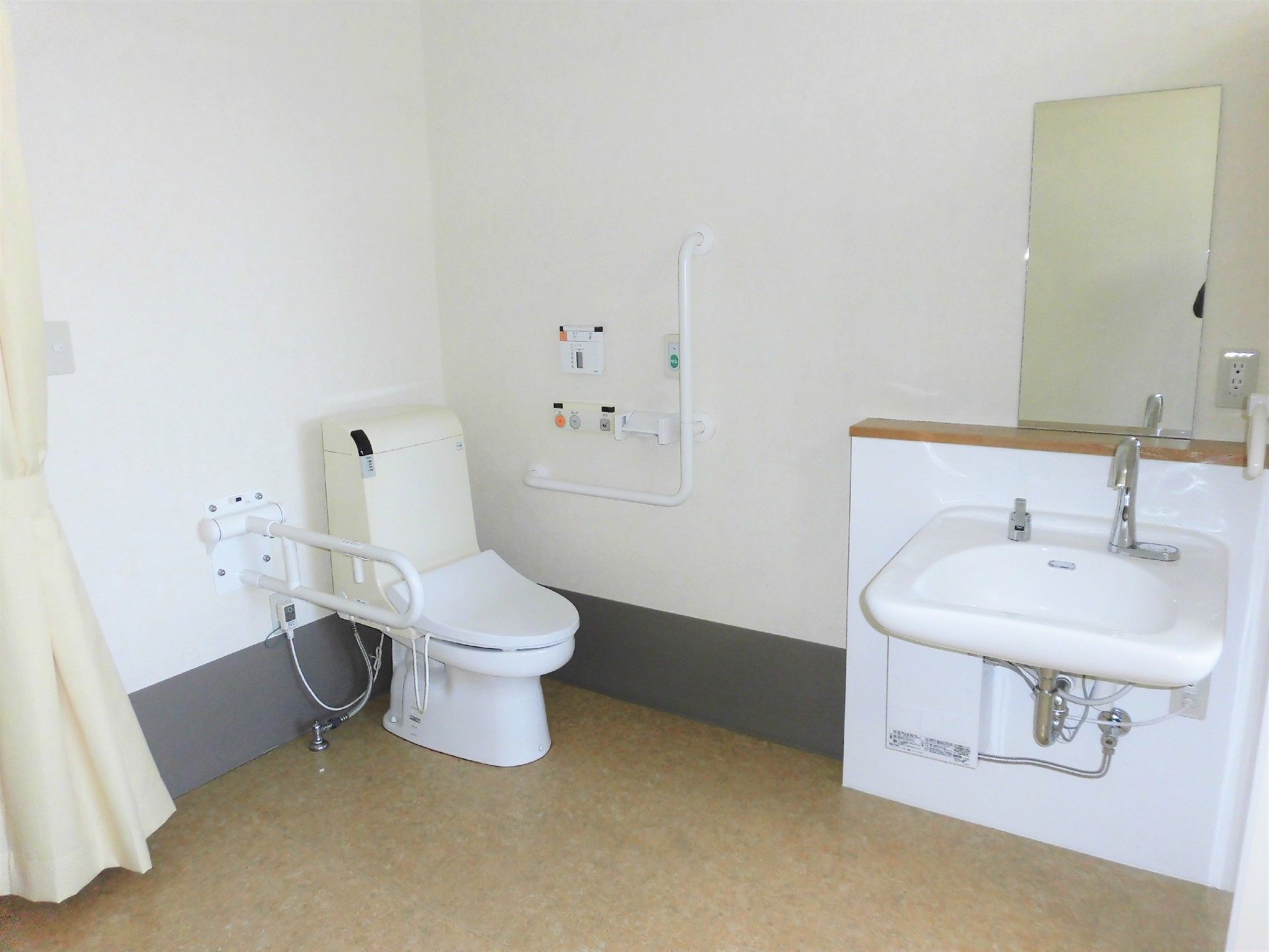 ドアレス設計の高齢者用トイレ。両側に手すりが付いている介護四季のトイレの様子