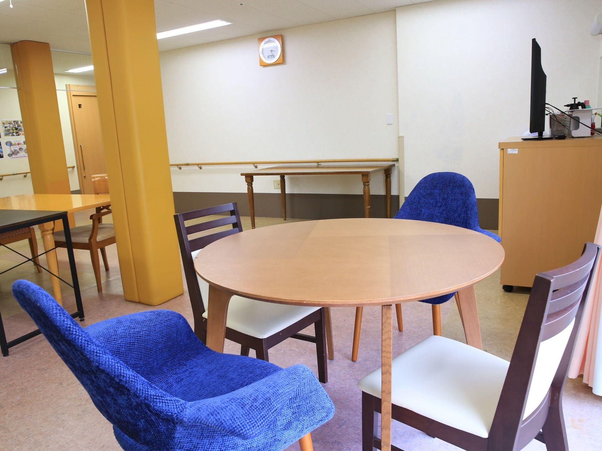 丸テーブルと椅子が４つ置かれた休憩スペースがある。椅子は２種類ある。窓際にあり、明るいスペースになっている。
