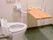 ふたのないトイレが設置され、広さも十分あり、可動式の木製の台が便器の前に設置されている。