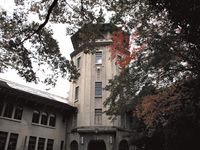 木の茂みの隙間から古い洋風調の建物が見える。施設の近くには、観光地としても有名な歴史ある建物が豊富に存在する。