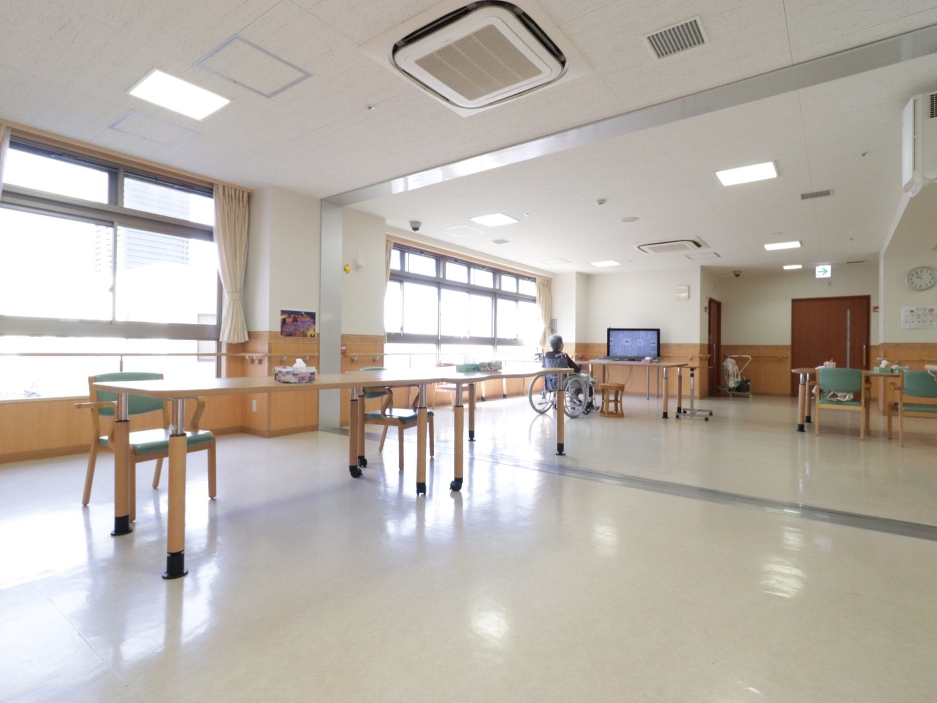 明るく開放的な共有スペースでは、車椅子をご利用の方にも楽に移動していただける。奥には皆で観られる大型のテレビが備わっている。