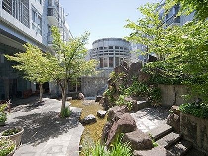 小川を挟んで木が植えられている自然な庭園が敷地内にある。
