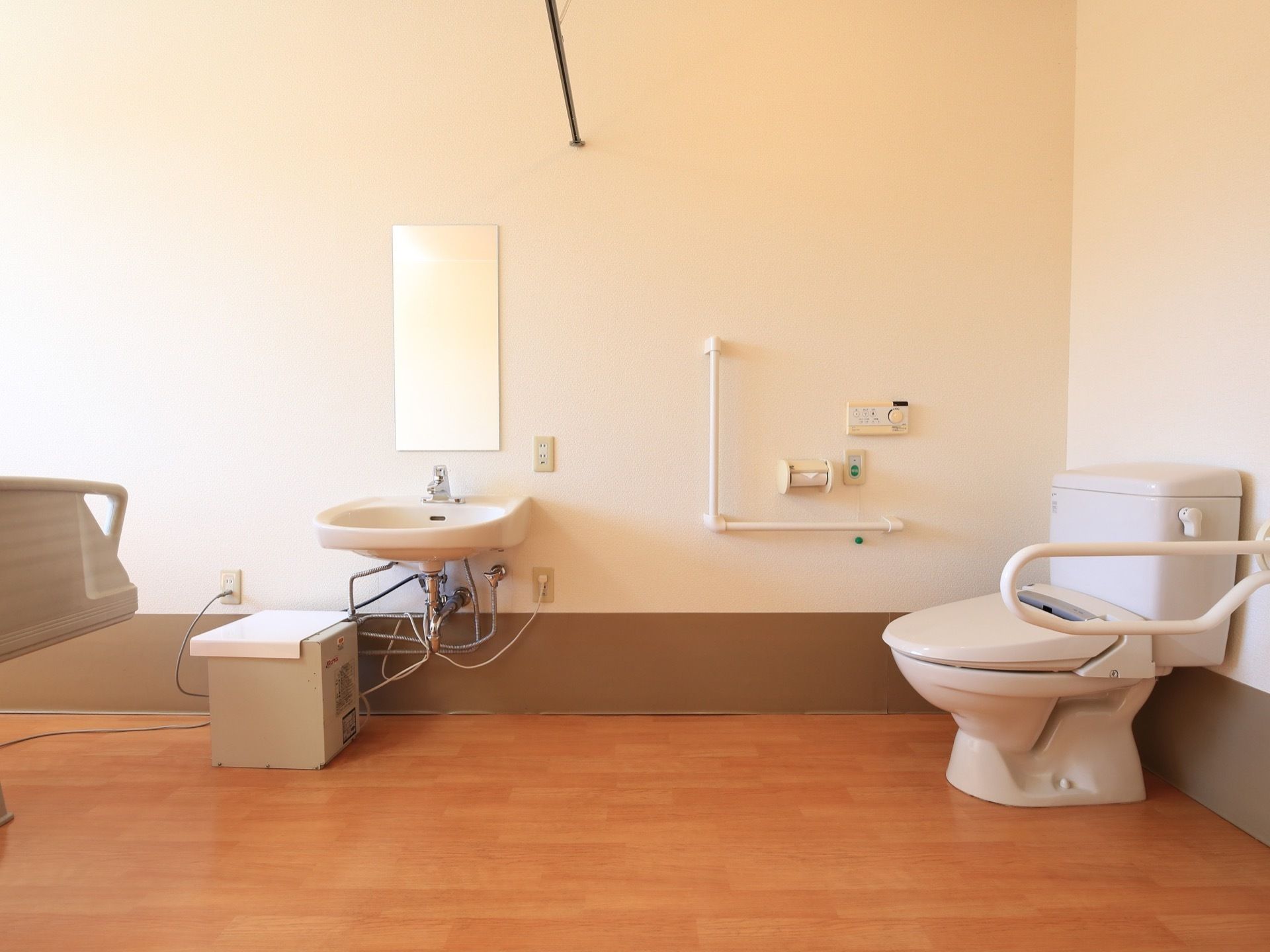 居室内には洗面台とトイレが併設され、仕切りはドアではなくカーテンである。手すりや呼び出しボタンを設置している。