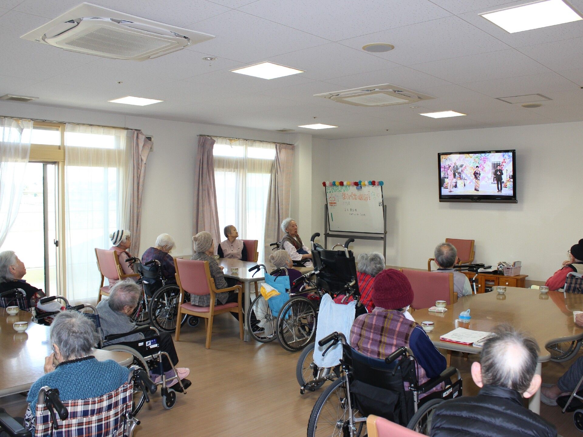 食堂にはテレビが付いていて、テーブルについている入居者たちがテレビを見たりぼんやりしていたりと、思い思いに過ごしている。