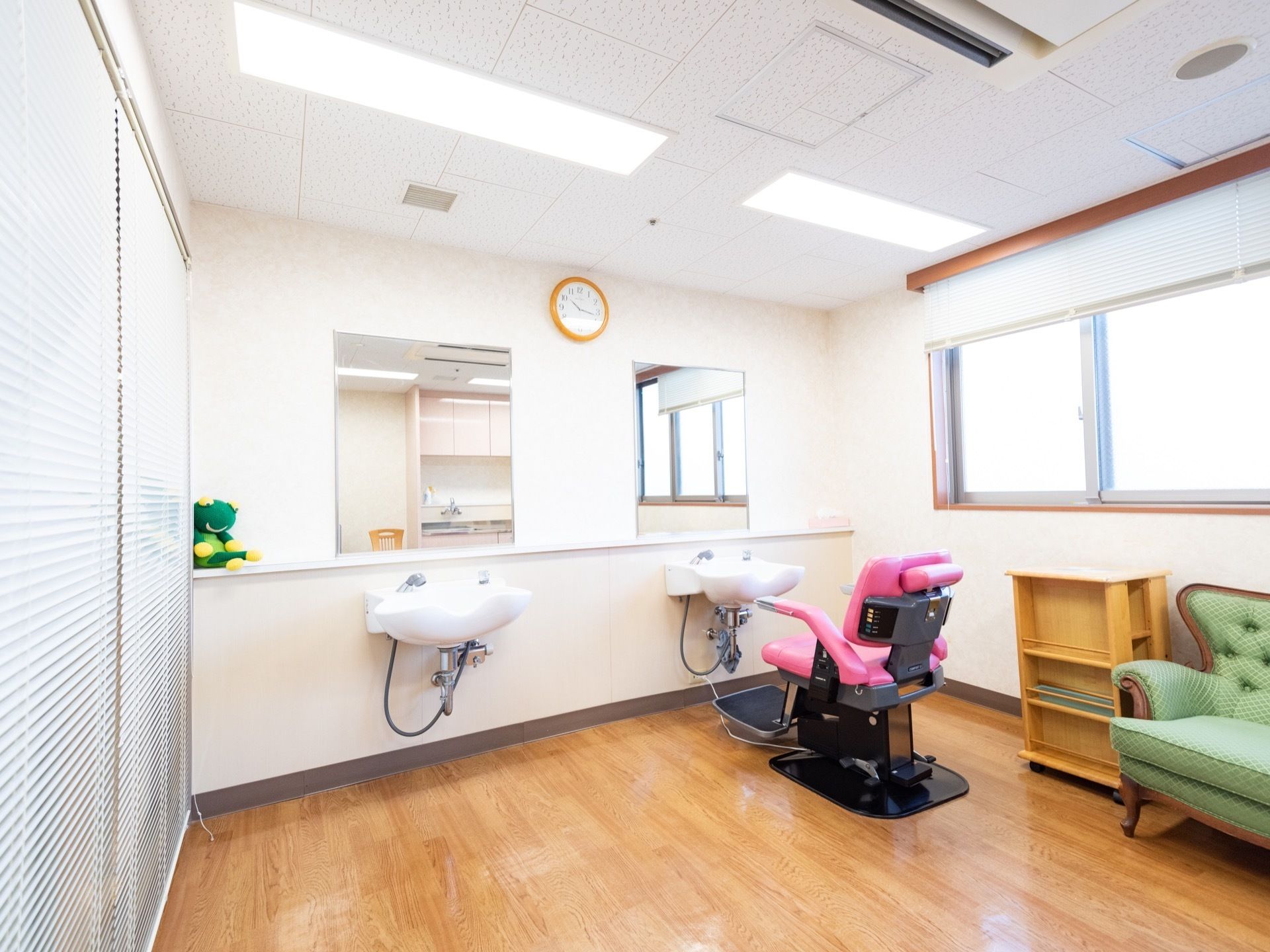 部屋の一画に鏡とシャワー台が設置されている。シャワー台の前にはヘアカットの際に使用する昇降式の椅子が置かれている。