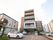 施設は５階建ての建物である。敷地内には車が２台停められている。フェンスを隔てた場所にも車が複数台ある。