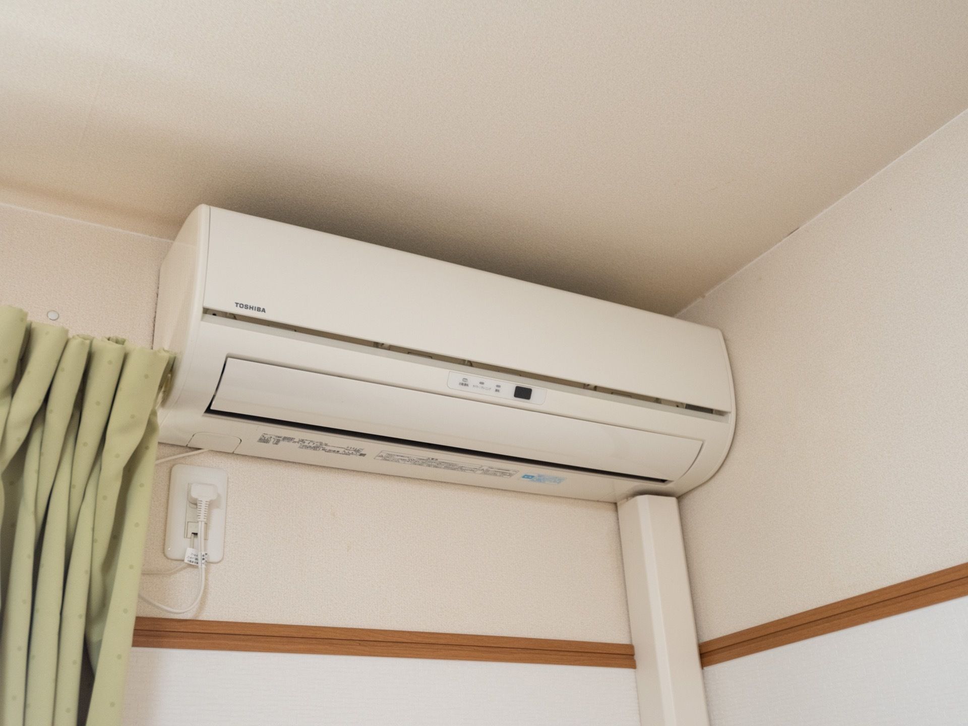 居室内に設置された白いエアコンである。ダクトカバーが壁に沿って取り付けられ、スッキリとした印象である。
