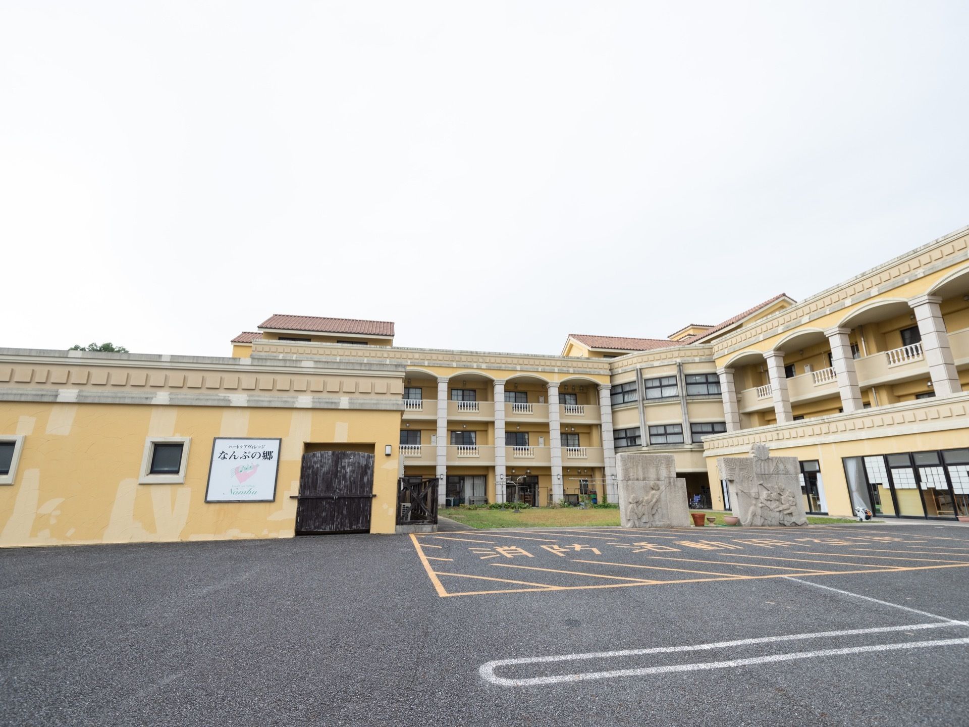 オレンジやイエローなどを取り入れたギリシャ様式の建物である。外壁に施設名の入った看板が設置されている。