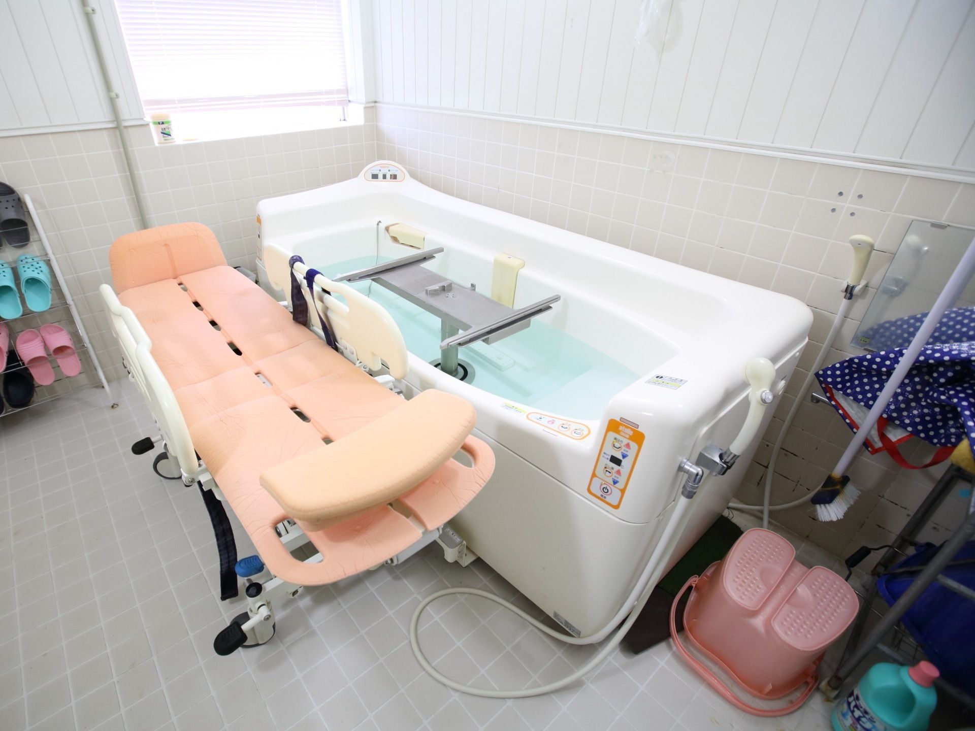明るく清潔感のある浴室に、機械浴槽と浴室用ストレッチャーがある。広々とした空間で入浴介助を受けられる。
