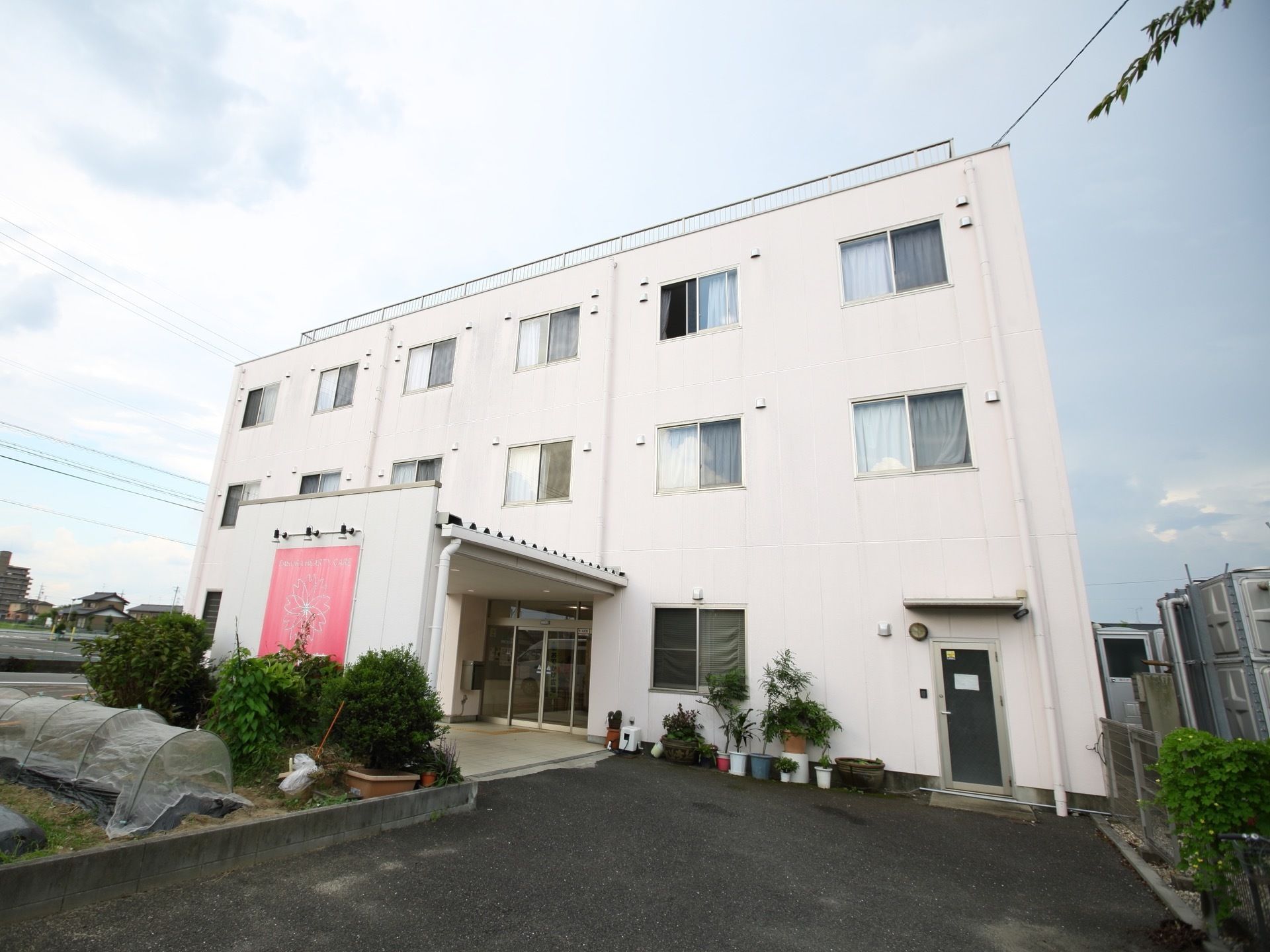 ３階建ての白塗りの建物で、集合住宅のような外観。エントランス周辺には菜園があり、さまざまな植物が育てられている。
