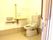 手すりや呼び出しボタンが付いたトイレはシンプルな造り。トイレのふたはない。