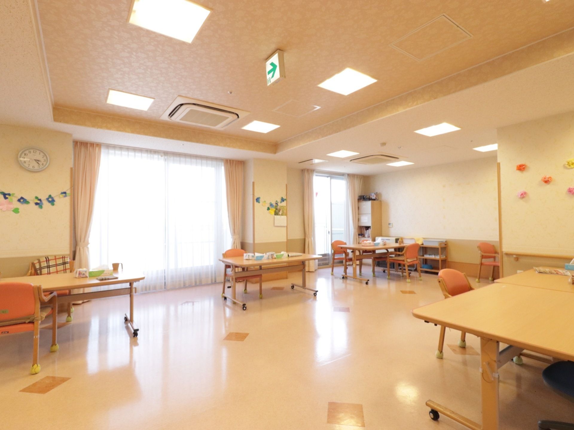明るい食堂に、キャスター付きのダイニングテーブルと脚にテニスボールが取り付けられた椅子が複数置かれている。