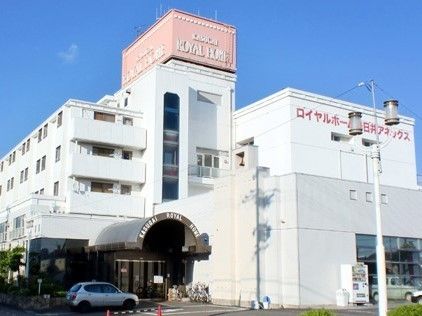 白い壁にピンク色の看板がついている建物