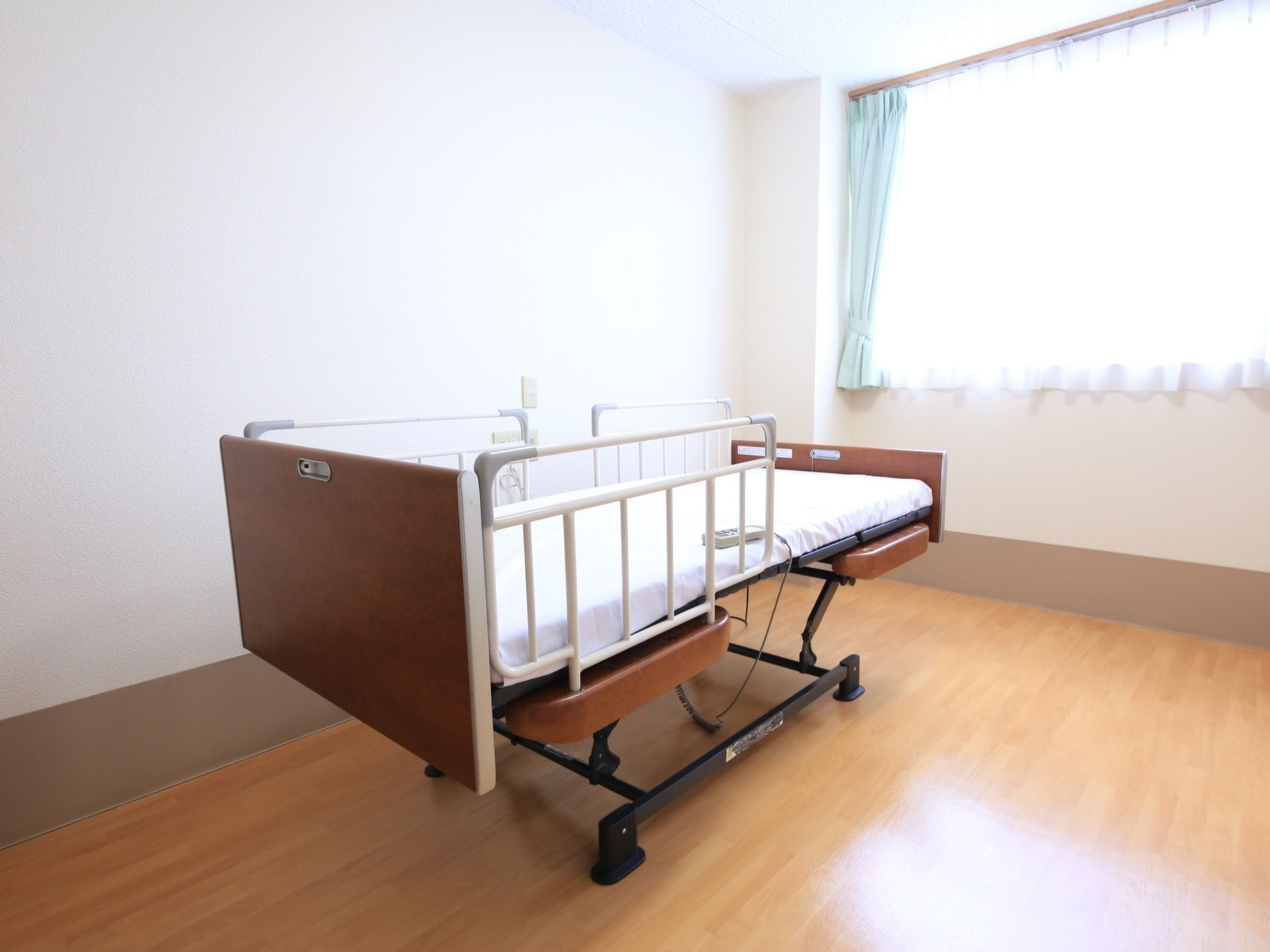 居室では、窓際の明るい場所に介護用ベッドが配置されている。高さや角度は、設置されたリモコンで自由に調節できる。