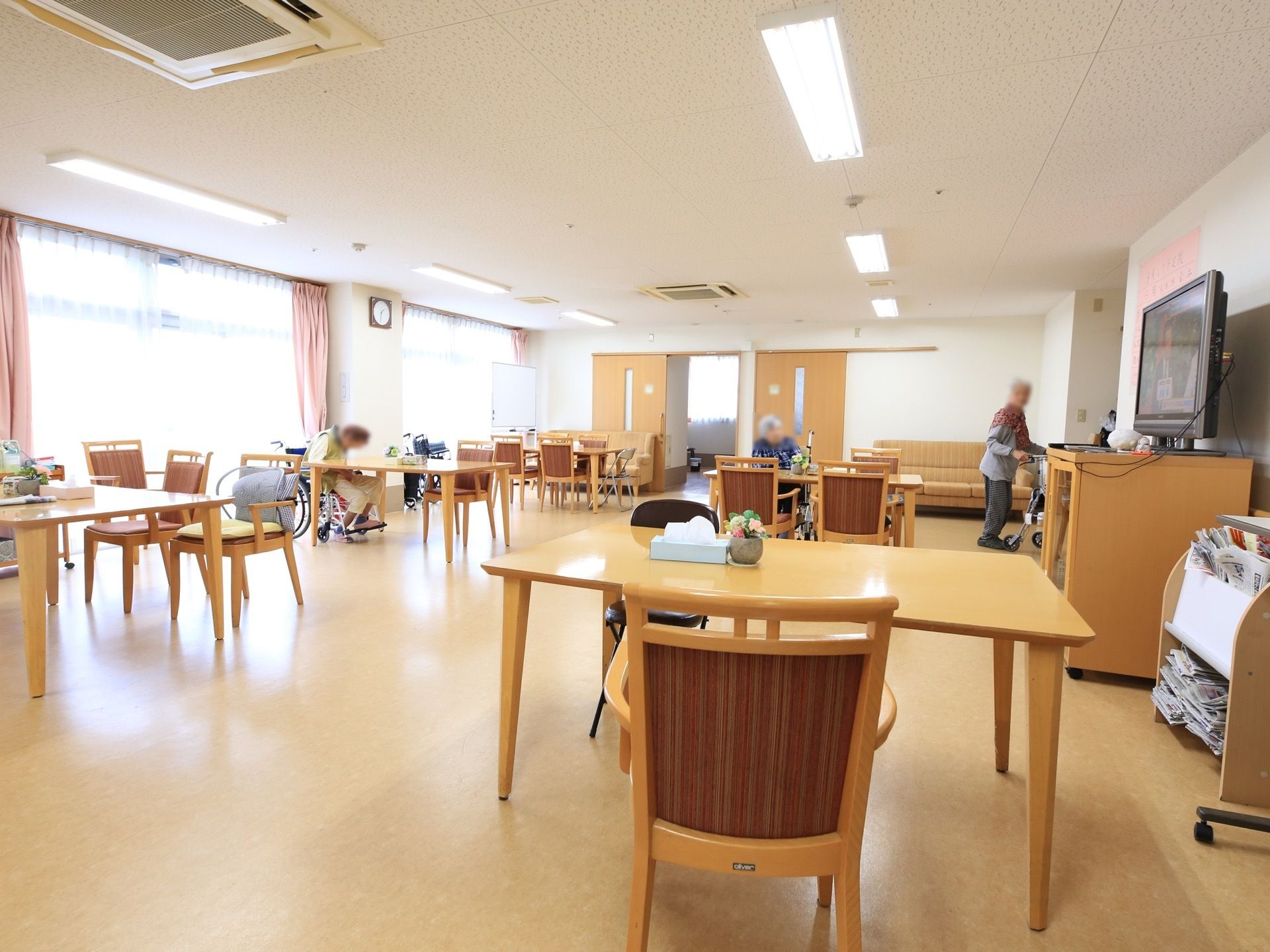 日中長い時間を過ごす場所なので、広々と開放的な造り。本棚には新聞が設置されて自由に読めるようになっている。