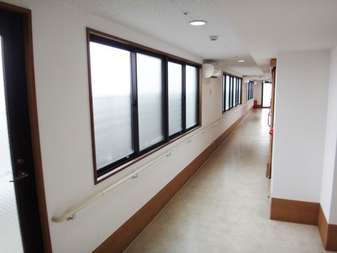 窓のある廊下の様子。まっすぐに手すりが取り付けられて安全を図ってある