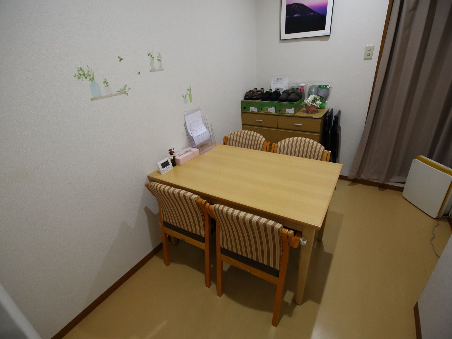 明るく落ち着いた雰囲気の部屋には、4人掛けのテーブルがある。奥の棚には、リハビリシューズの見本が展示してある。