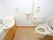 洗面台がついた広めのトイレの様子。手すりと緊急コールがあるトイレ