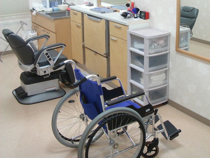 理美容室には通常のいすだけでなく車いすが置かれている。鏡や収納棚が並んでいる。