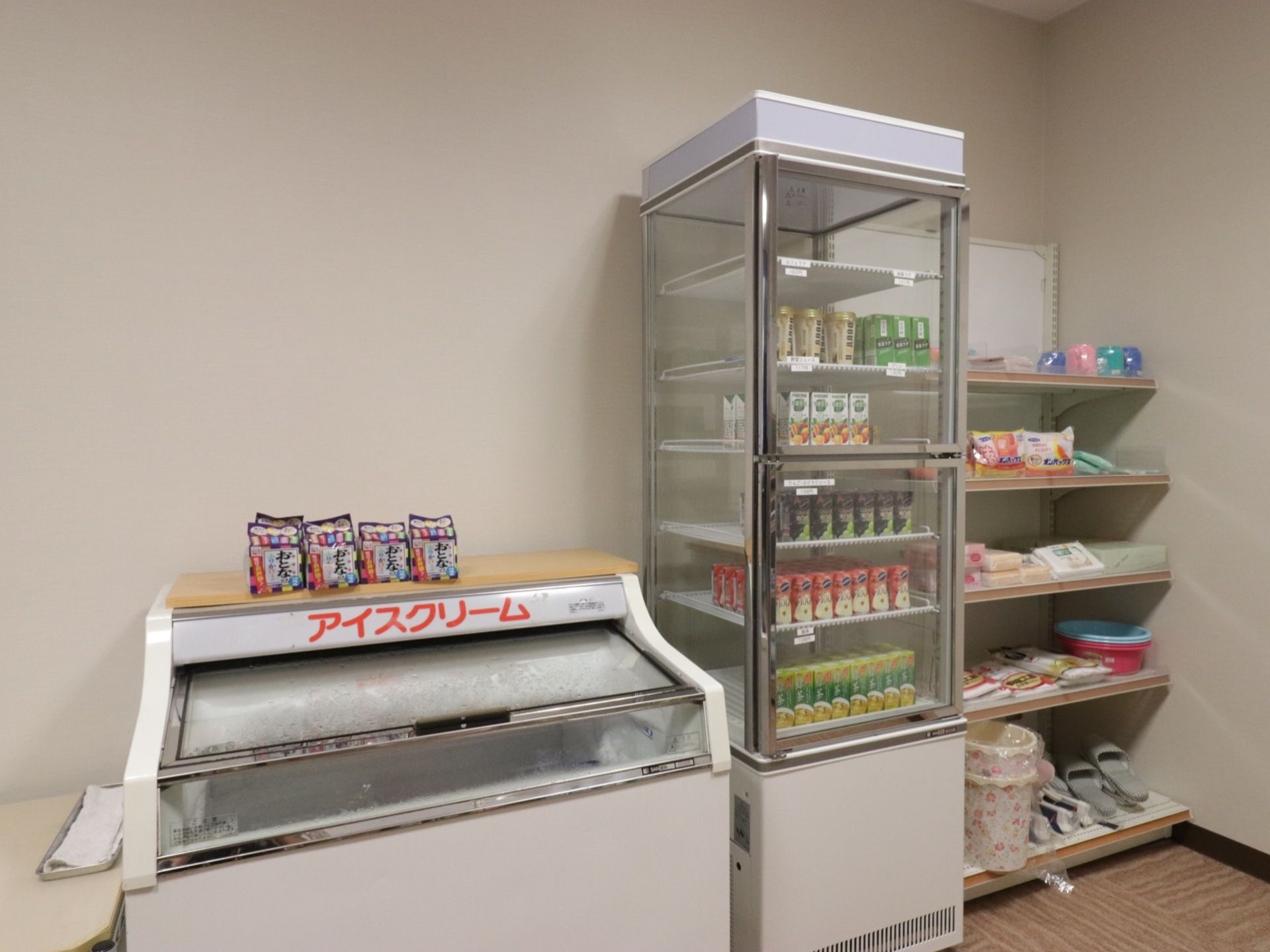 施設内には売店があり、アイスやドリンクなどが販売されている。その隣の棚には、日用品も並べられている。