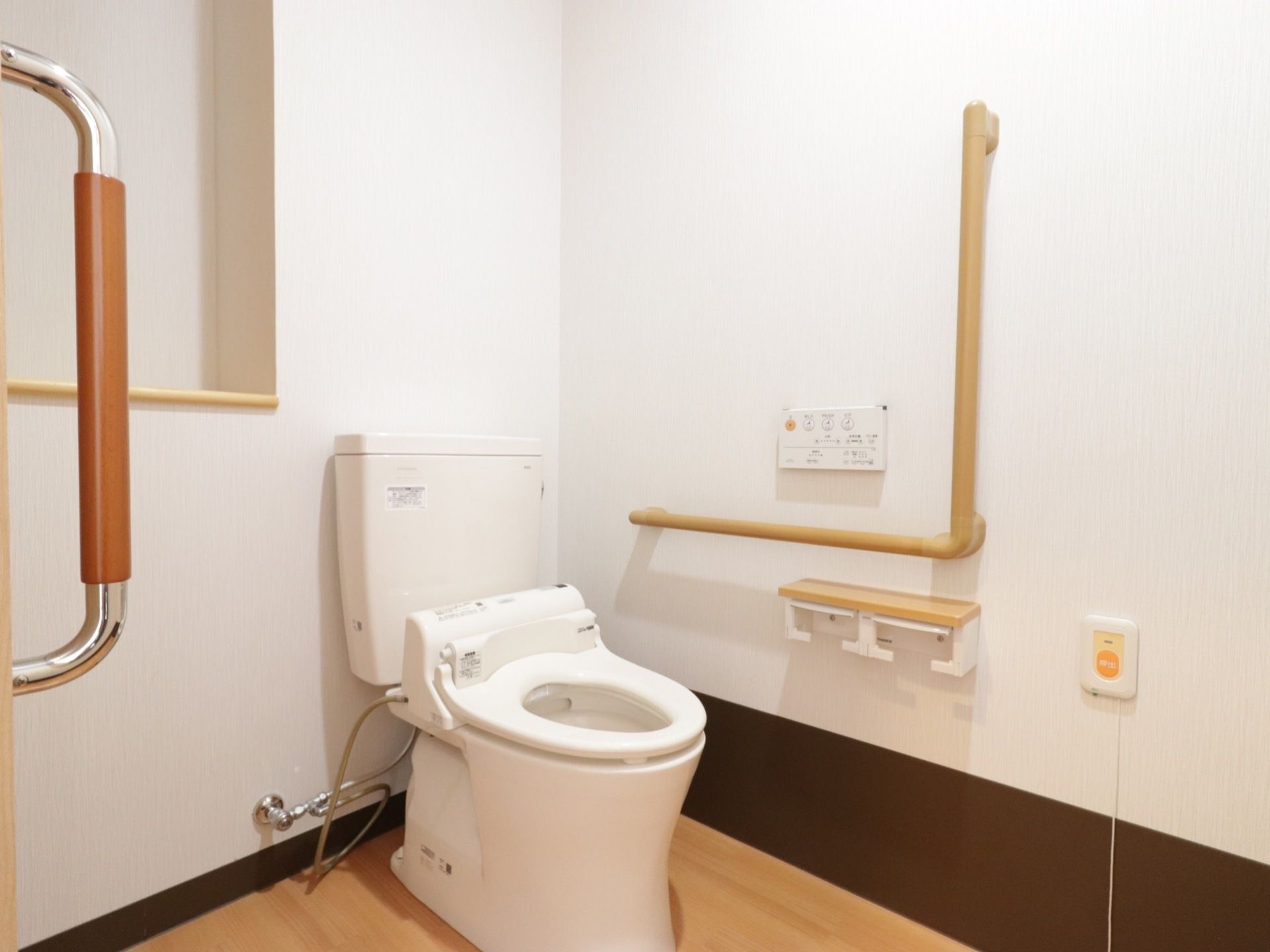 トイレは、車椅子でも利用しやすい広さが確保されている。壁には、トイレットペーパー掛けが設置されている。