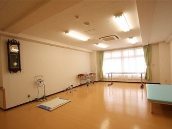 広いフロアに、平行棒など運動器具が置いてある。いつまでも健康に過ごせるよう、歩行訓練やリハビリなどを実施している。