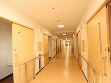 居室が並ぶ廊下には、壁から各ドアの前にまで手すりが渡されているので、掴まりながら移動できるようになっている。