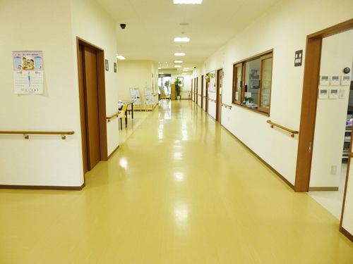 車椅子と歩行者が安心してすれ違える広さの廊下である。壁に沿って転倒防止の手すりが取り付けられている。