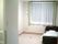 薄いベージュの床と白い壁の居室。窓が大きくとられている。部屋にはトイレがあり、介護用ベッドが備え付けられている。