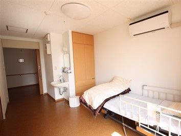 廊下から居室内へ入ると、洗面スペースやベッドまで、段差のない床で安心して移動していただけることがわかる。