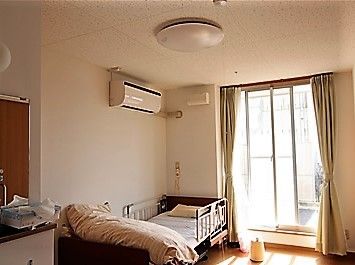 居室内は備え付けのエアコンや電動のベッドのほかに、ナースコールがベッド頭上側にさりげなく設置されている。