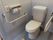 トイレはタイル張りで、清潔感のある内装になっている。安全のため、壁には手すり、便座には可動式の手すりを設置している。